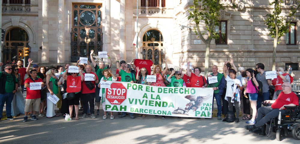 Activistas de la PAH (Plataforma de Afectadas por la Hipoteca) y otros movimientos sociales se concentran frente a un edificio institucional de Barcelona. Sostienen una pancarta que reclama &ldquo;Por el derecho a la vivienda&rdquo; y carteles de &ldquo;Stop Desahucios&rdquo;